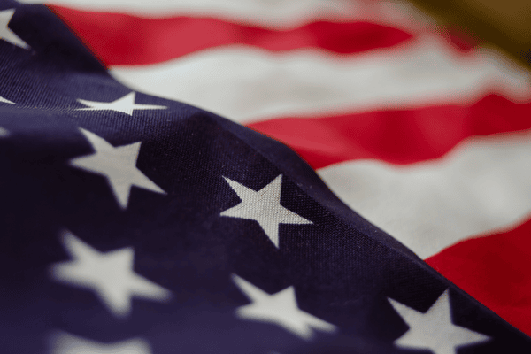 Close-up of the American flag showing white stars on blue and red and white stripes.