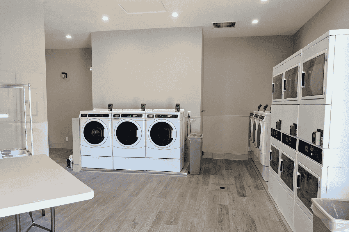 Modern laundry facilities at Oak Creek RV Resort featuring multiple washers and dryers in a bright, clean environment.